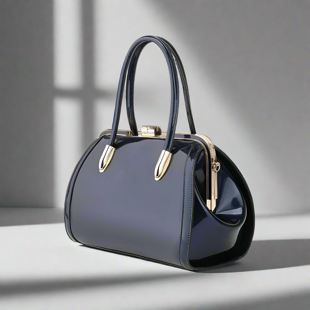 Navy patent leather handbag with a gemstone kiss lock clasp, top handles, and a detachable shoulder strap. Spacious interior with protective feet and a glossy finish for an elegant look.