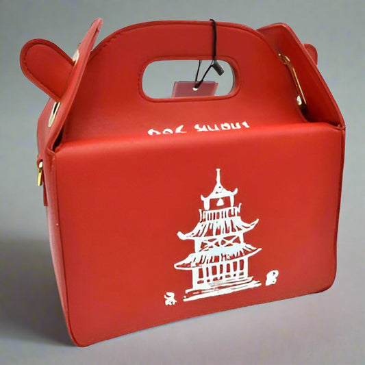 Chinese Takeout Box Bag in PU faux leather with a square box shape, hasp closure, and a playful design inspired by a takeout box. Features a cell phone pocket and folded handle.